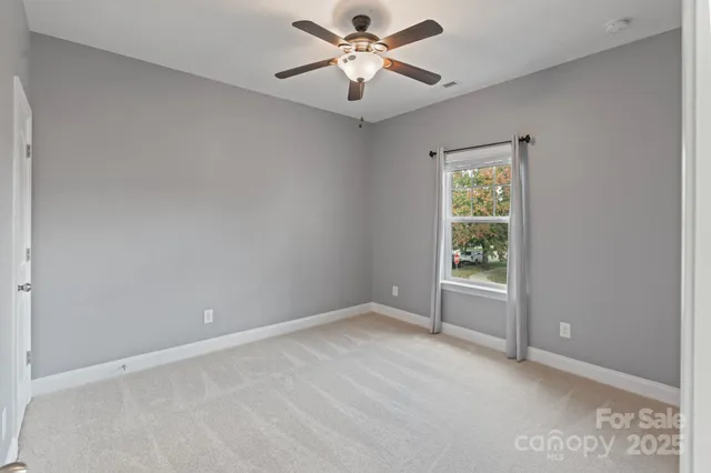 a view of a room with a ceiling fan and a window