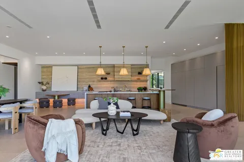 a living room with furniture a chandelier and a fireplace
