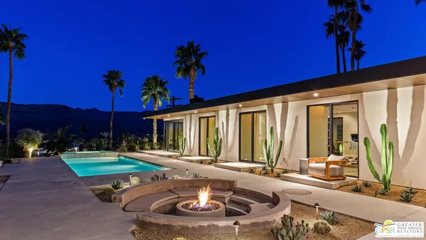 a view of a house with backyard sitting area and garden