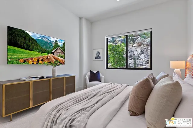a view of a house with a small yard plants and large tree