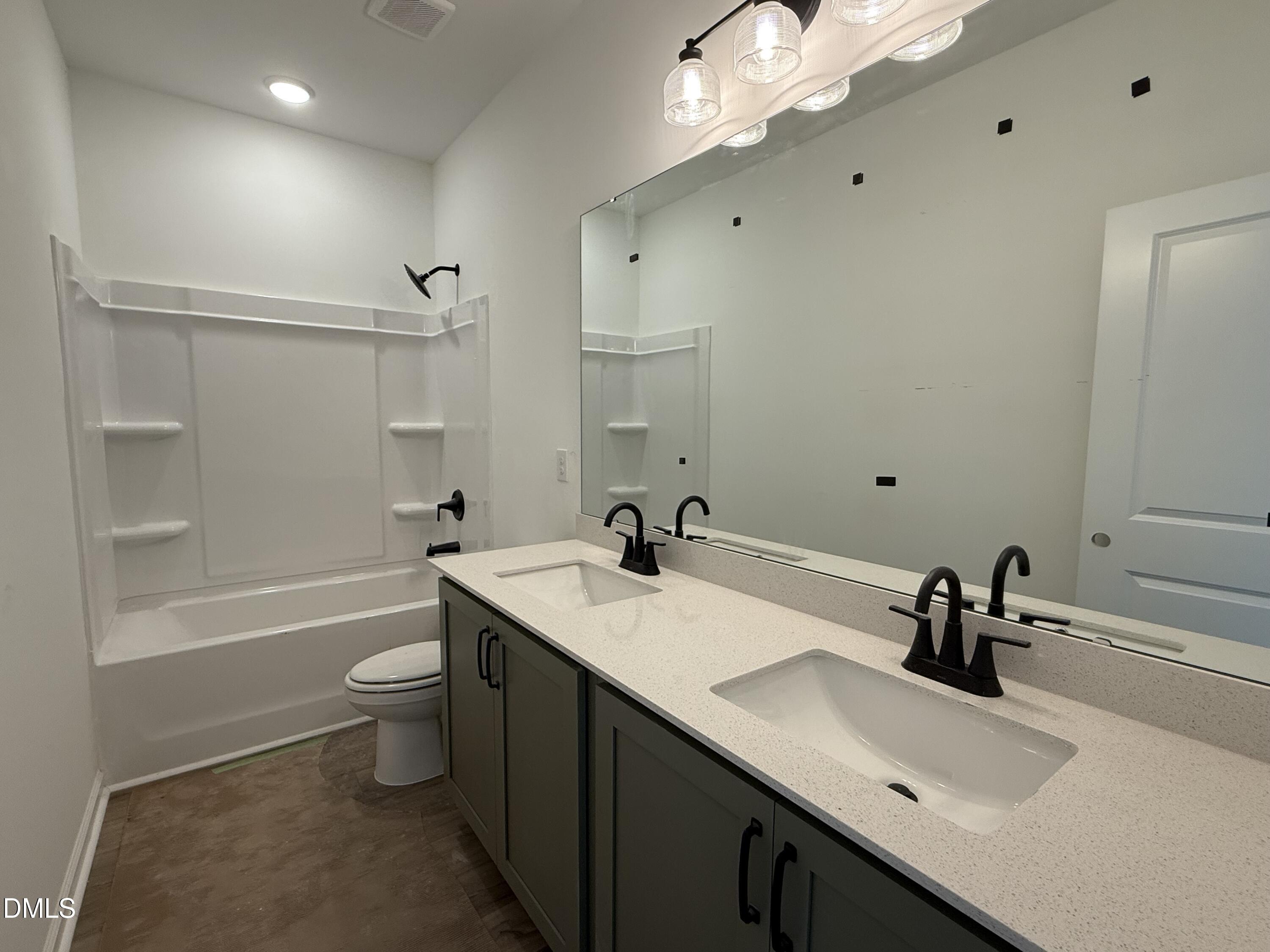 508 Contempo Court, Unit 39 Rolesville, NC 27571 - Photo 15 of 37 a bathroom with a sink a toilet a mirror and shower