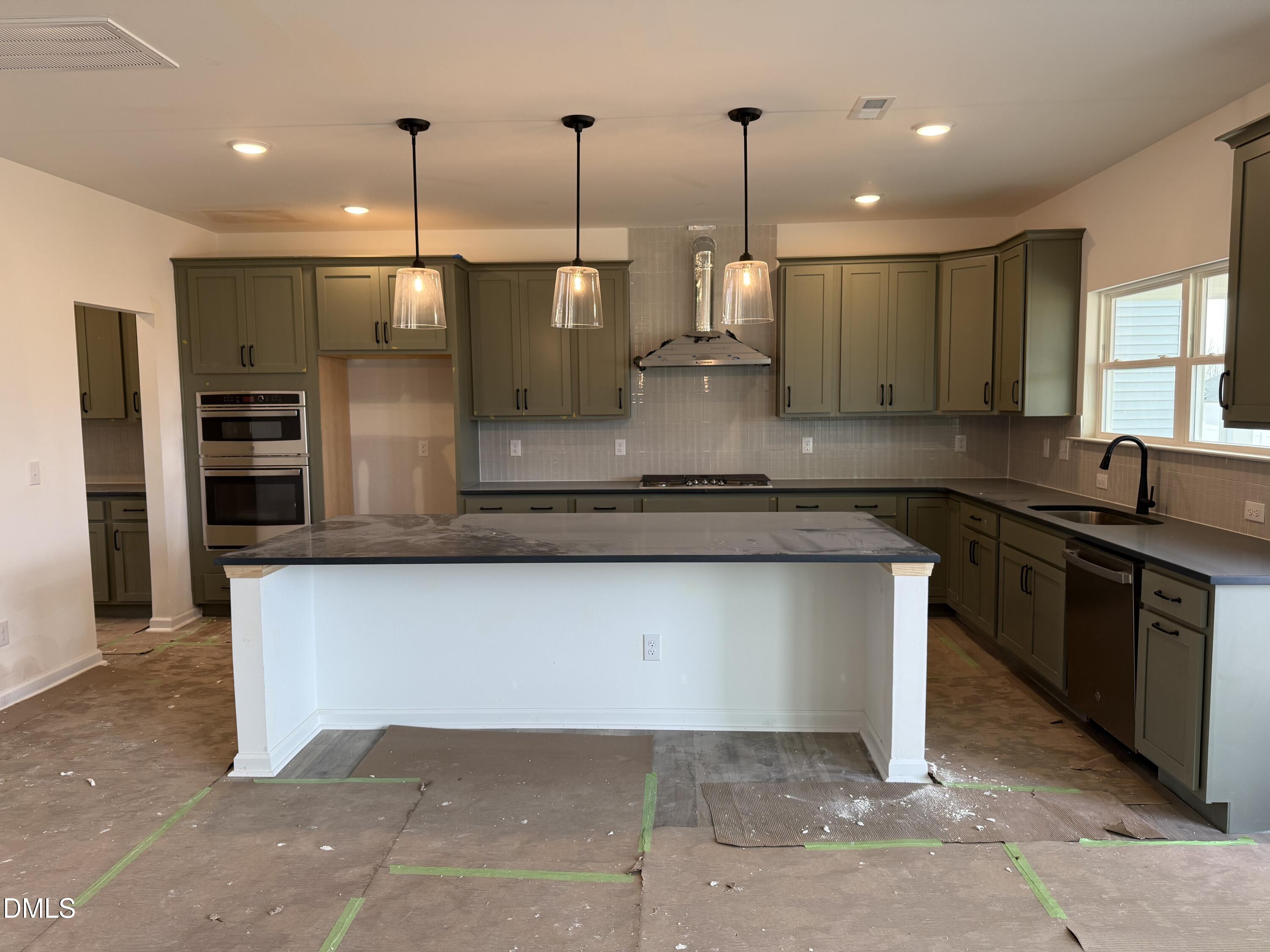 508 Contempo Court, Unit 39 Rolesville, NC 27571 - Photo 5 of 37 a kitchen with stainless steel appliances granite countertop a sink a stove and a wooden floors