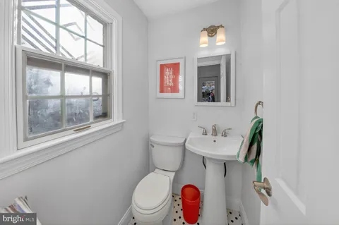 a bathroom with a toilet a sink and a window