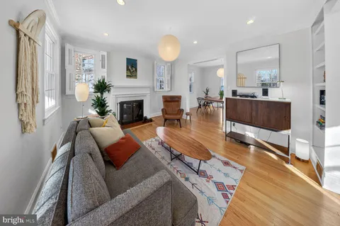 a living room with fireplace furniture and a large window