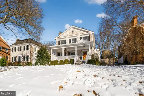 a view of a white house with a yard covered in snow