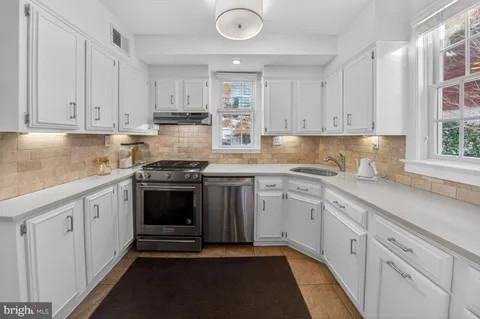 a kitchen with granite countertop a sink stainless steel appliances and cabinets