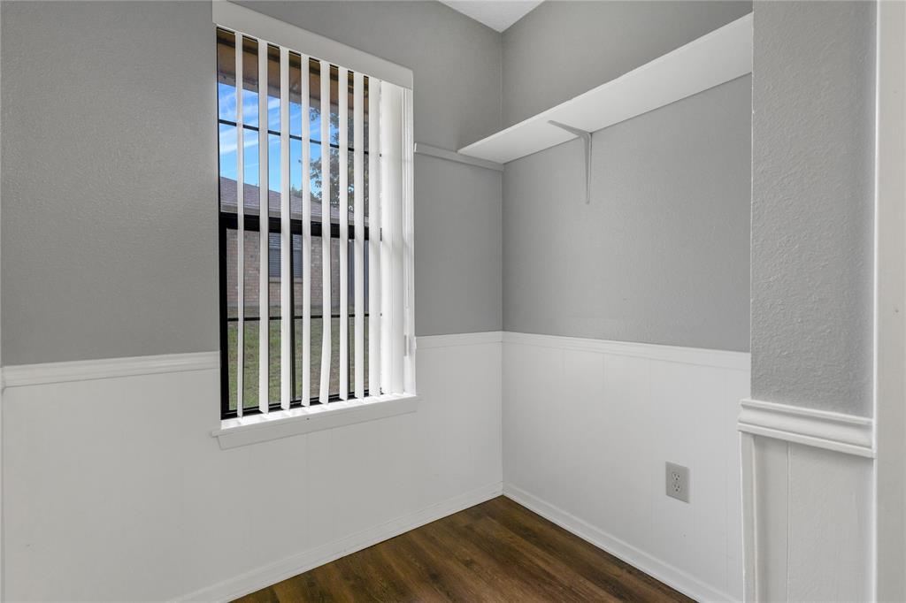 1609 Robin Street Mineola, TX 75773 - Photo 9 of 24 Recessed window with vertical blinds, wood-finish flooring, two-tone wall treatment, built-in shelving, and white baseboards
