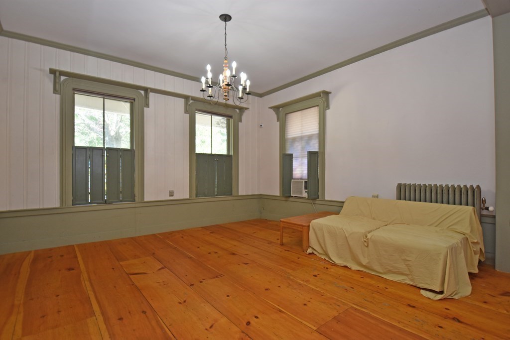 52 Central Street Gardner, MA 01440 - Photo 11 of 38 a bedroom with a bed and a chandelier