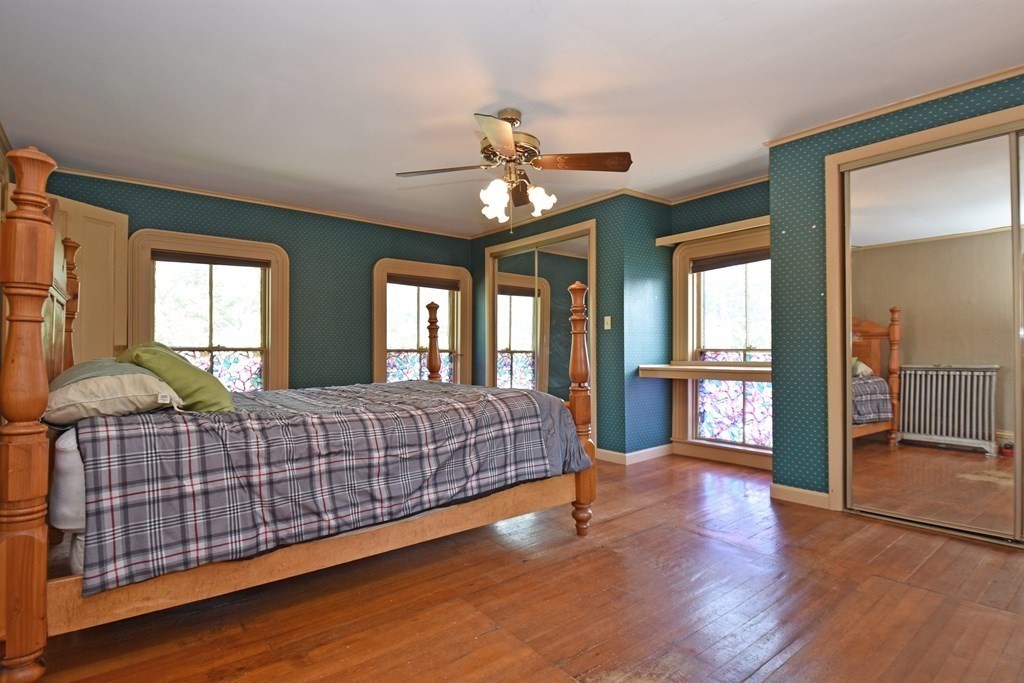 52 Central Street Gardner, MA 01440 - Photo 29 of 38 a spacious bedroom with a balcony a bed and a chandelier