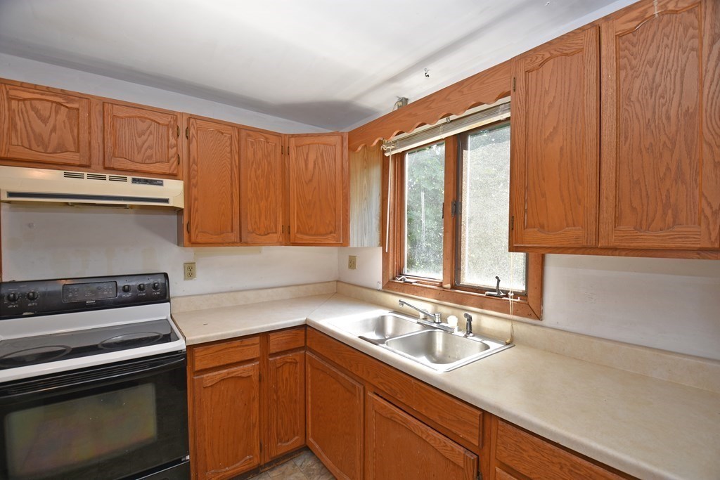 52 Central Street Gardner, MA 01440 - Photo 32 of 38 a kitchen with a sink stove and cabinets