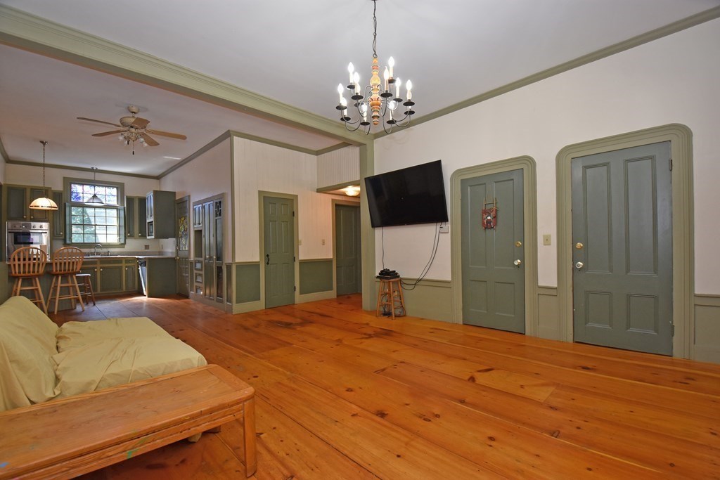52 Central Street Gardner, MA 01440 - Photo 10 of 38 a bed room with a bed mirror and a chandelier