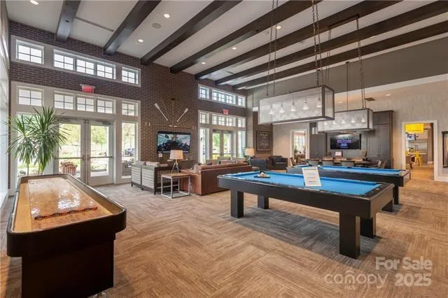 a living room with furniture a pool table and a large window