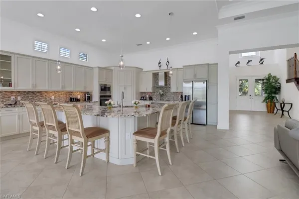 a kitchen with a dining table chairs and white cabinets