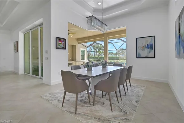 a dining room with furniture a chandelier and wooden floor