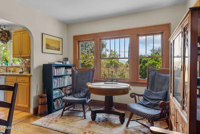 a view of a workspace with furniture and a window
