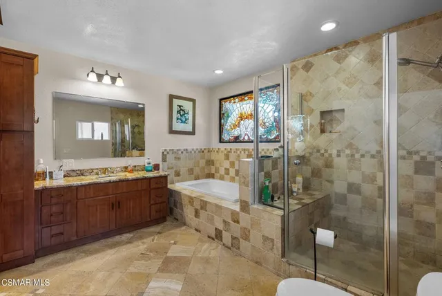 a spacious bathroom with a large tub shower and sink