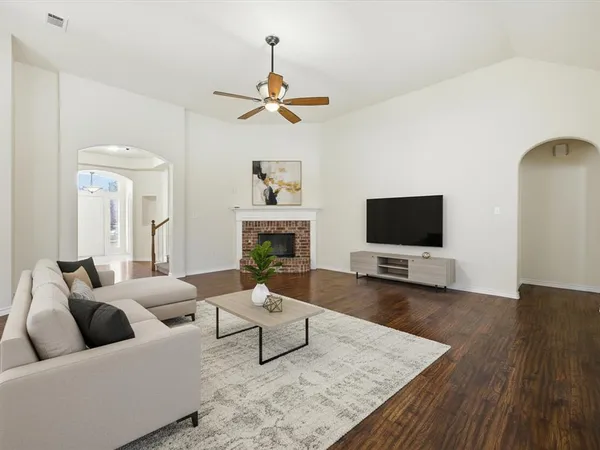 a living room with furniture a flat screen tv and a fireplace