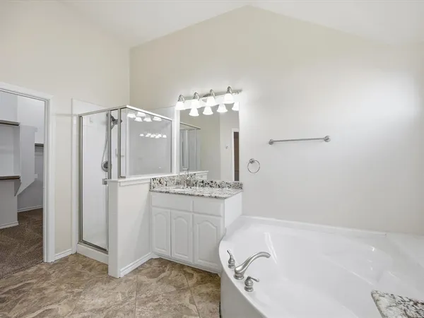 a bathroom with a tub sink and mirror
