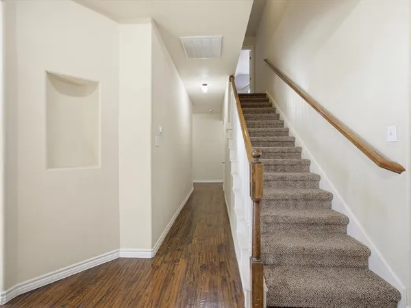 a view of a hallway with wooden floor and entryway