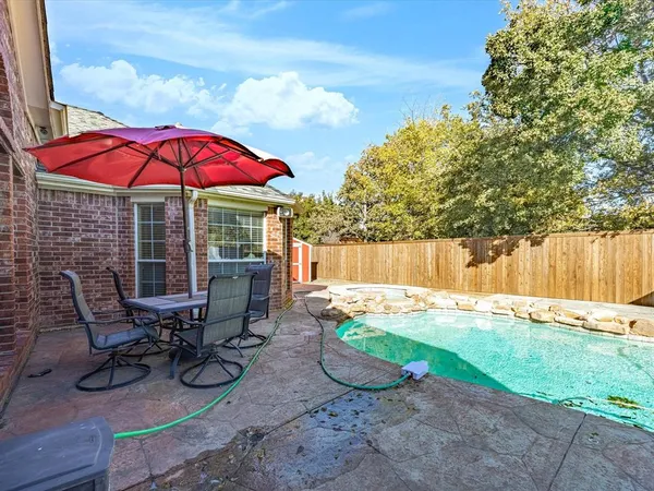 a view of backyard with swimming pool and patio