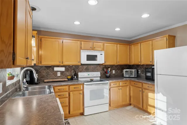 a kitchen with a sink a stove and white cabinets