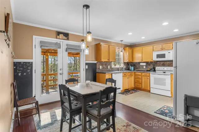a kitchen with a refrigerator a stove dining table and chairs