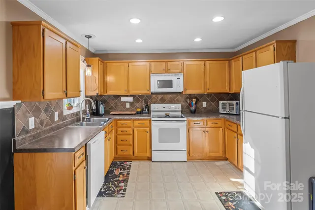a kitchen with stainless steel appliances granite countertop a refrigerator a stove a sink and a microwave