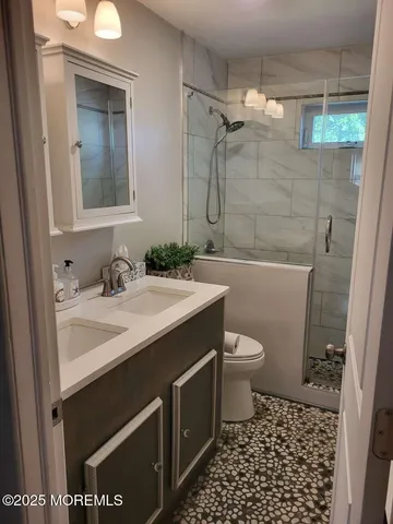 a bathroom with a sink a toilet and shower