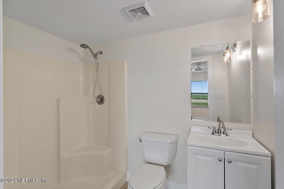 3100 Ocean Shore Boulevard, Unit 106 Ormond Beach, FL 32176 - Photo 9 of 21 a bathroom with a toilet a sink a mirror and vanity