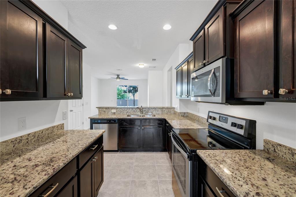 4824 Poolside Drive St. Cloud, FL 34769 - Photo 3 of 29 a kitchen with a stove sink and microwave
