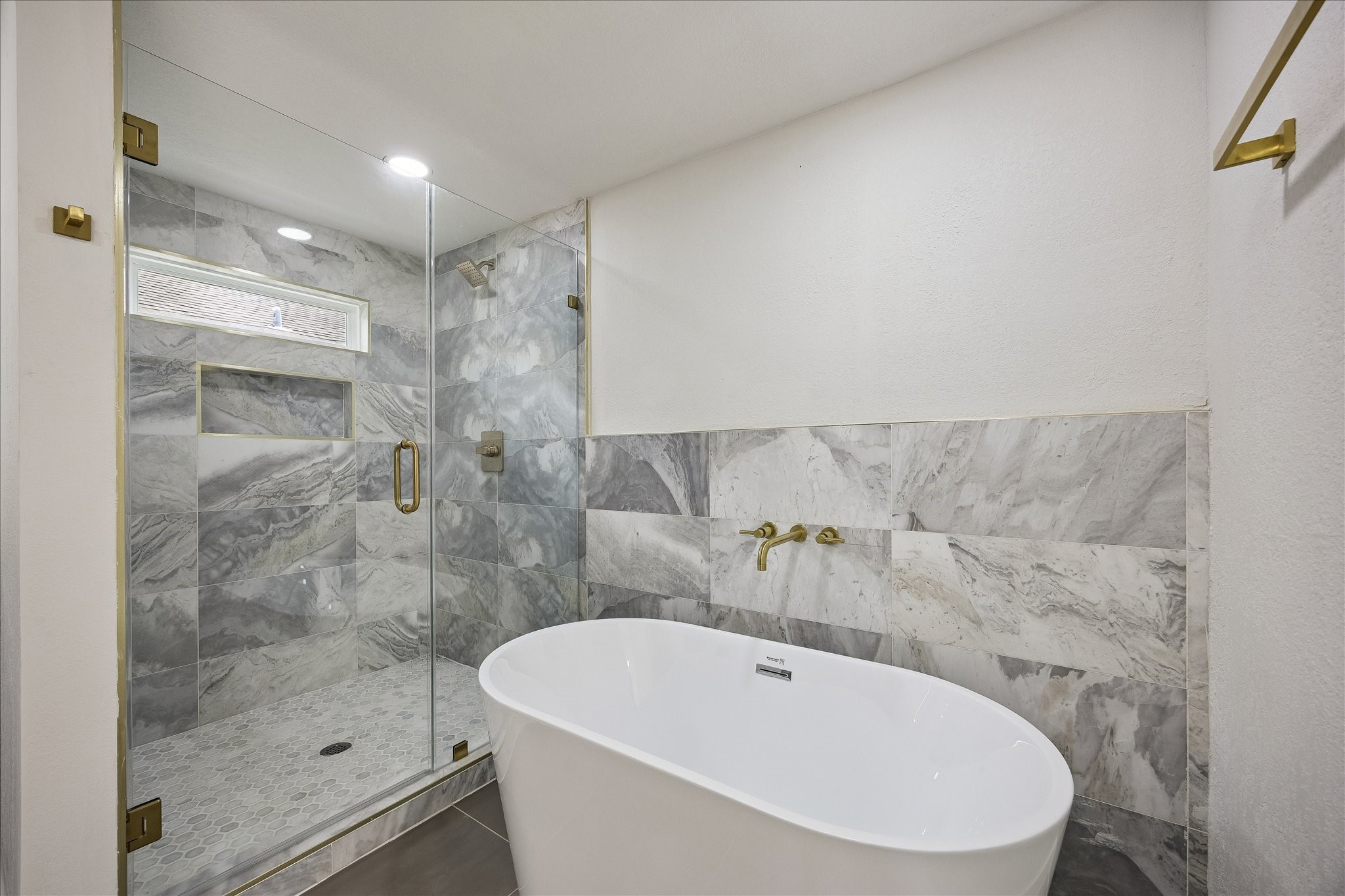 1630 Tabor Street Houston, TX 77009 - Photo 17 of 25 The glass enclosed shower is adorned with marble like tile and brass hardware accents.