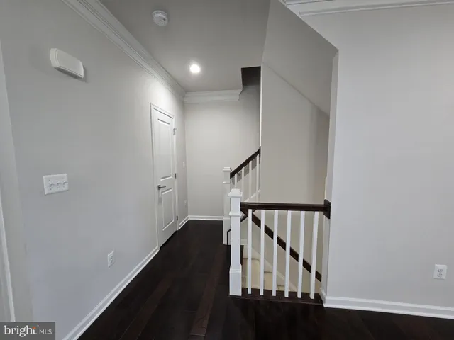 a view of staircase with railing and white walls