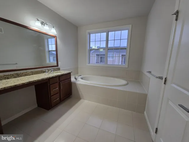 a bathroom with a bathtub sink and mirror