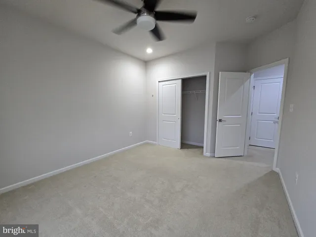 an empty room with closet and windows