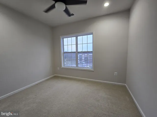an empty room with a window and a ceiling fan
