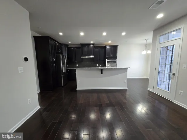 a view of a kitchen with a sink and wooden floor