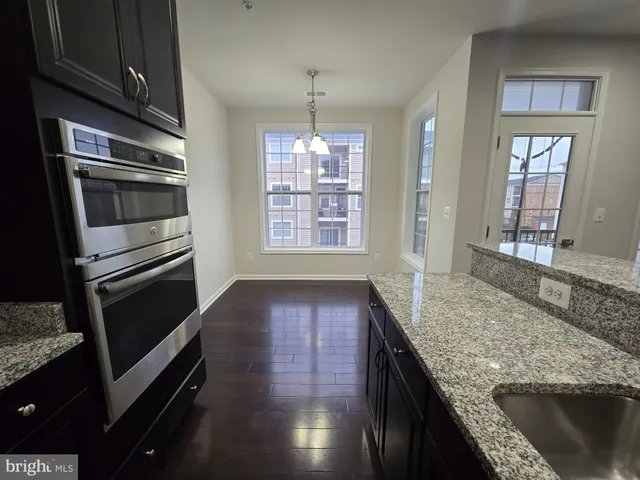 a kitchen with granite countertop stainless steel appliances a stove sink and microwave