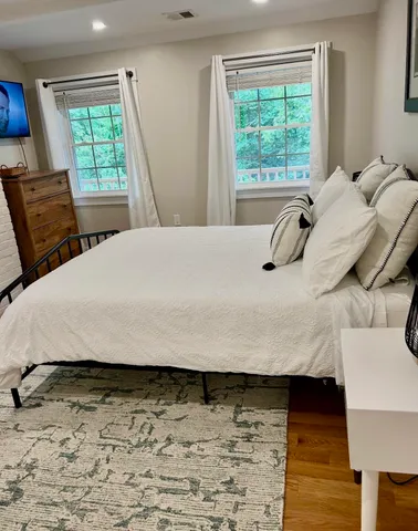 a bed sitting in a bedroom next to a window