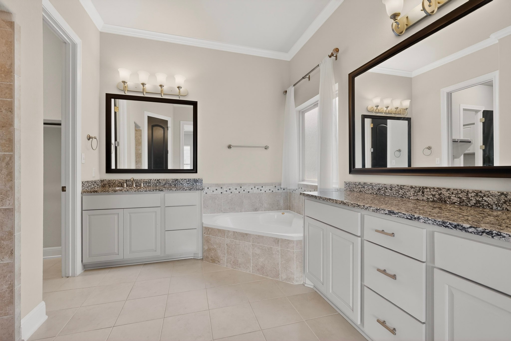 2617 Milan Meadows Drive Leander, TX 78641 - Photo 13 of 40 Dual vanities with granite counters and a corner soaking tub define this elegant bathroom.
