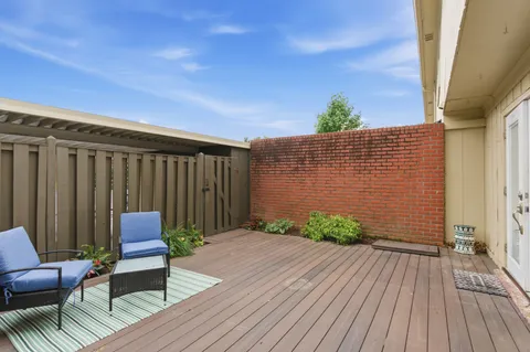 a backyard of a house with wooden floor and outdoor seating