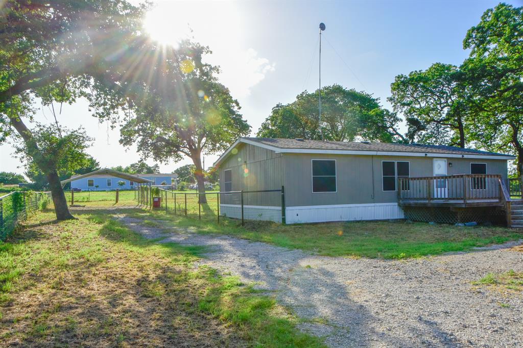 a view of a house with a yard and a large tree