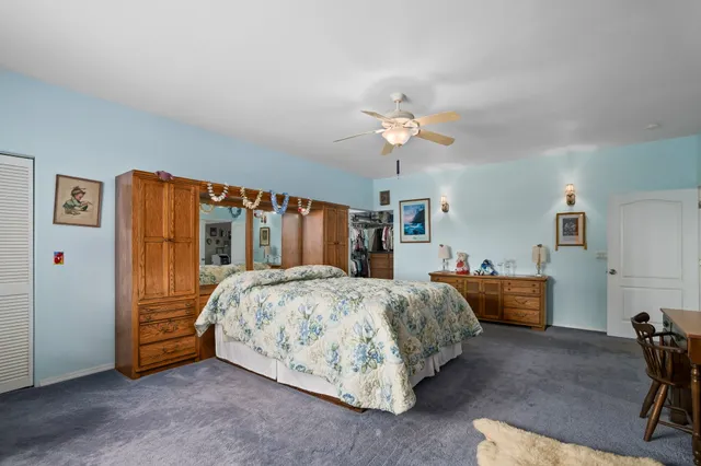 a spacious bedroom with a bed and a chandelier