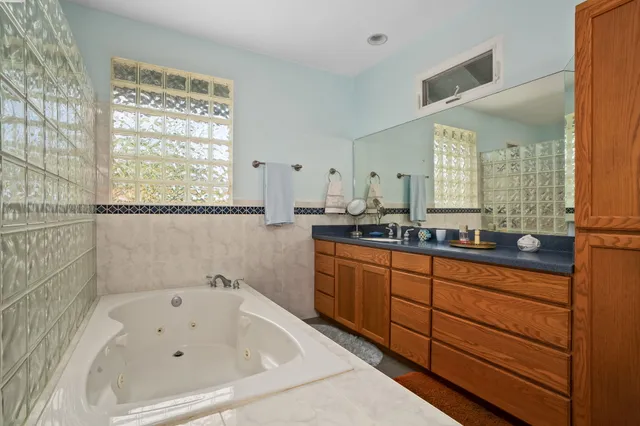 a bathroom with a bathtub sink and mirror