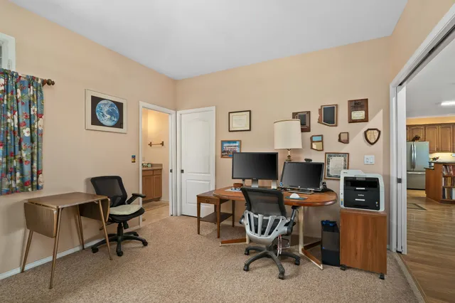 a view of a workspace with furniture and a window