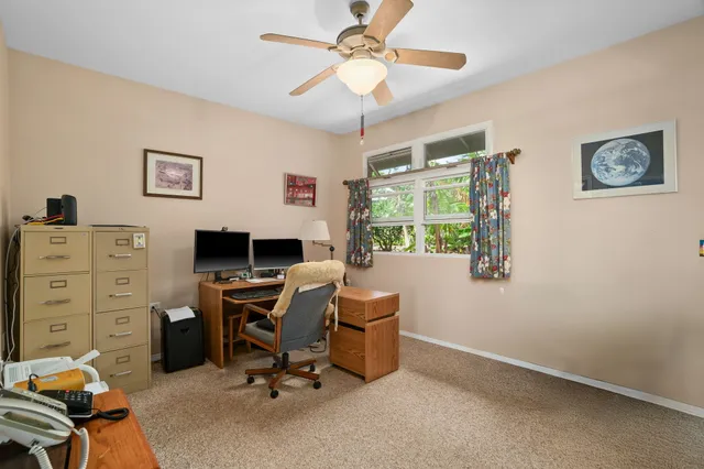 a view of a workspace with furniture and a window