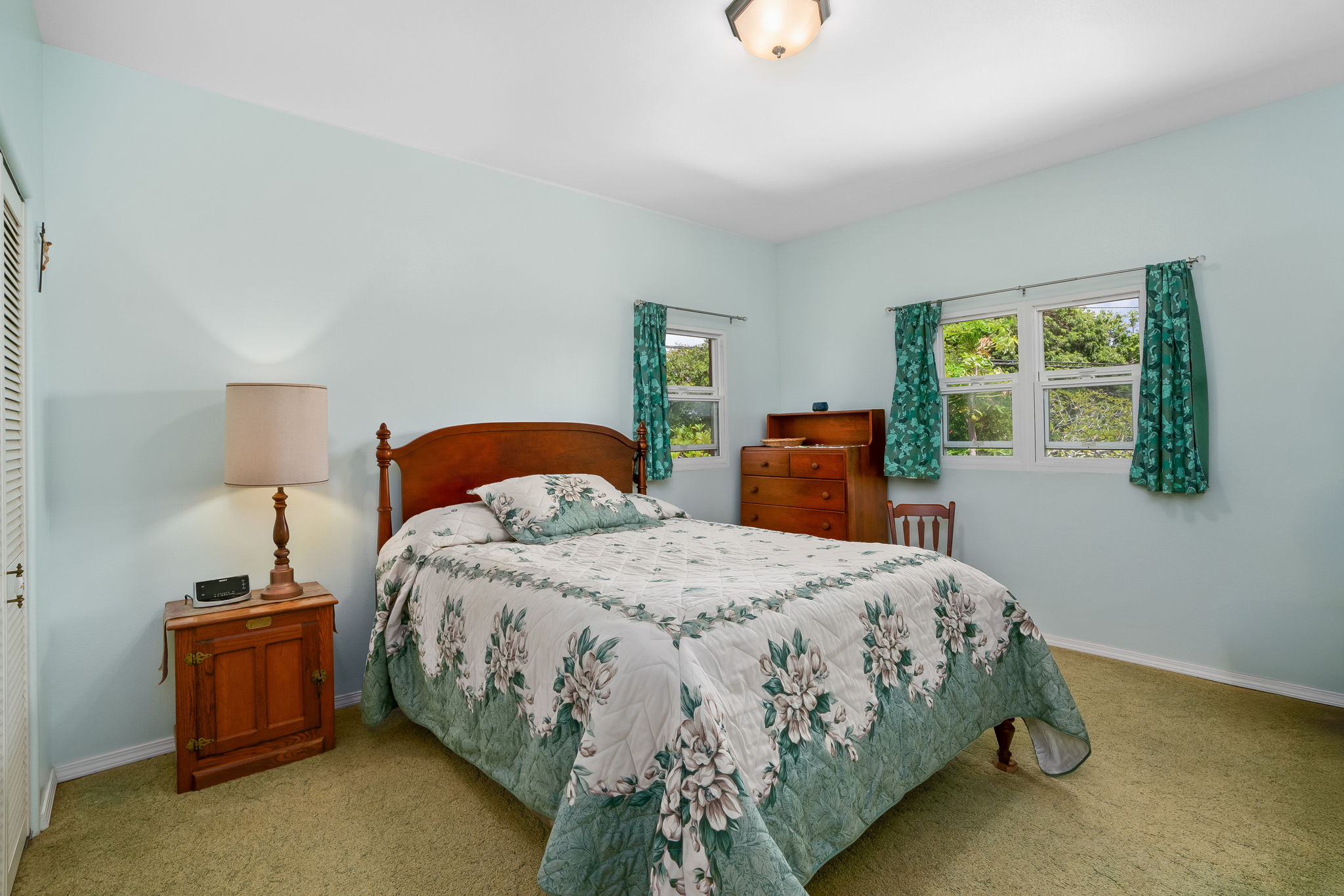 3837 Papalina Road Kalaheo, HI 96741 - Photo 23 of 26 a bedroom with a bed and a lamp on table