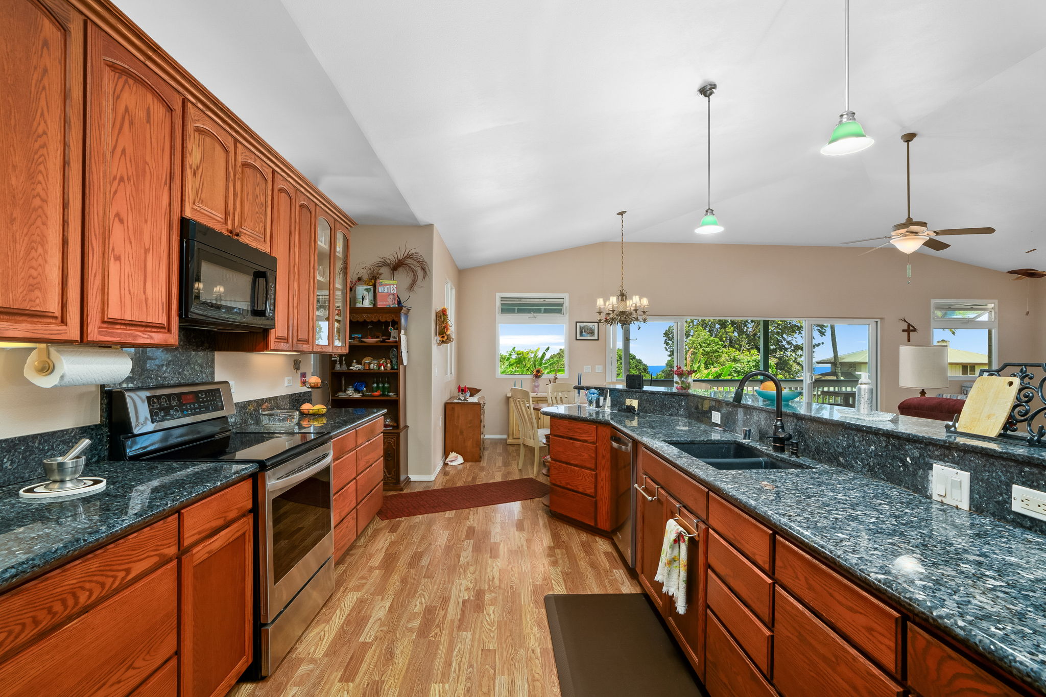 3837 Papalina Road Kalaheo, HI 96741 - Photo 8 of 26 a kitchen with stainless steel appliances a sink dishwasher a stove top oven a refrigerator with wooden cabinets and floor