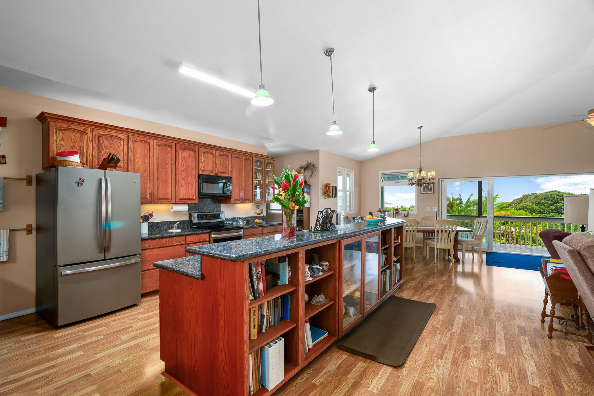 3837 Papalina Road Kalaheo, HI 96741 - Photo 9 of 26 a kitchen with stainless steel appliances granite countertop a refrigerator a sink dishwasher a stove and a dining table with wooden floor
