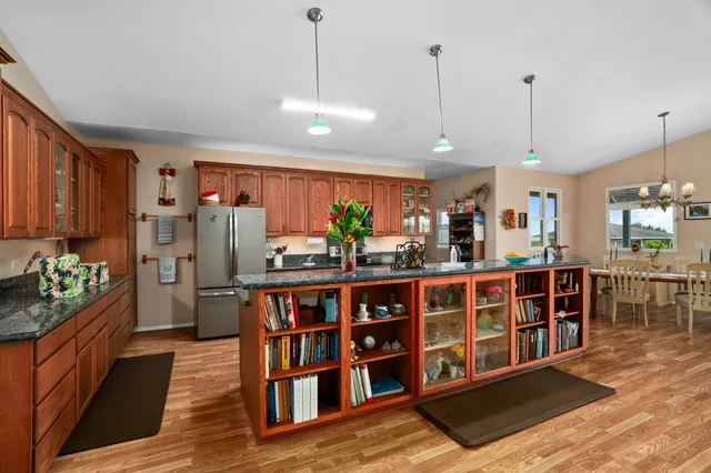a room with lots of wooden furniture a chandelier and a book shelf