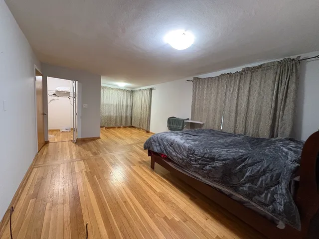 a spacious bedroom with a bed and a mirror